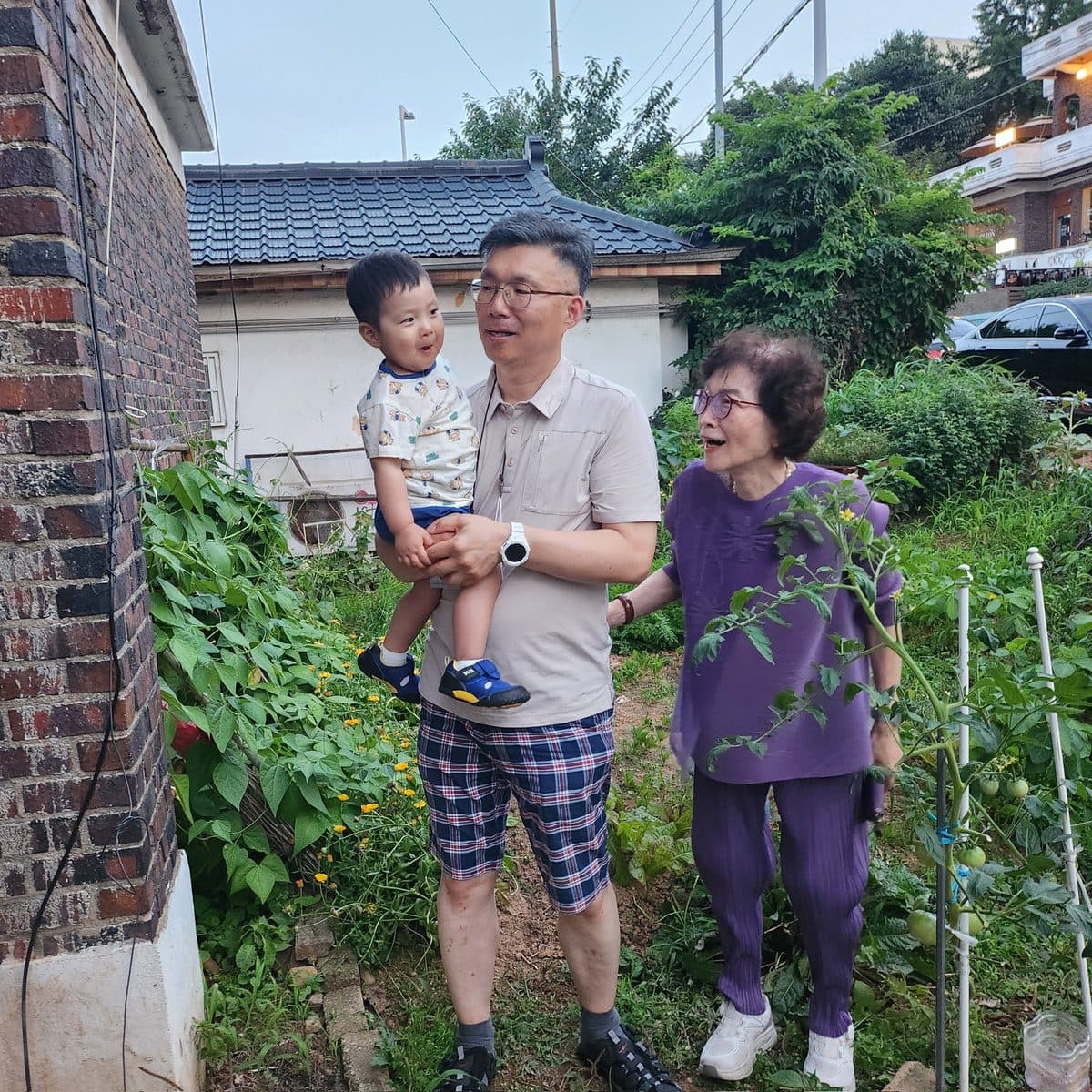 손자와 함께 텃밭을 거닐며